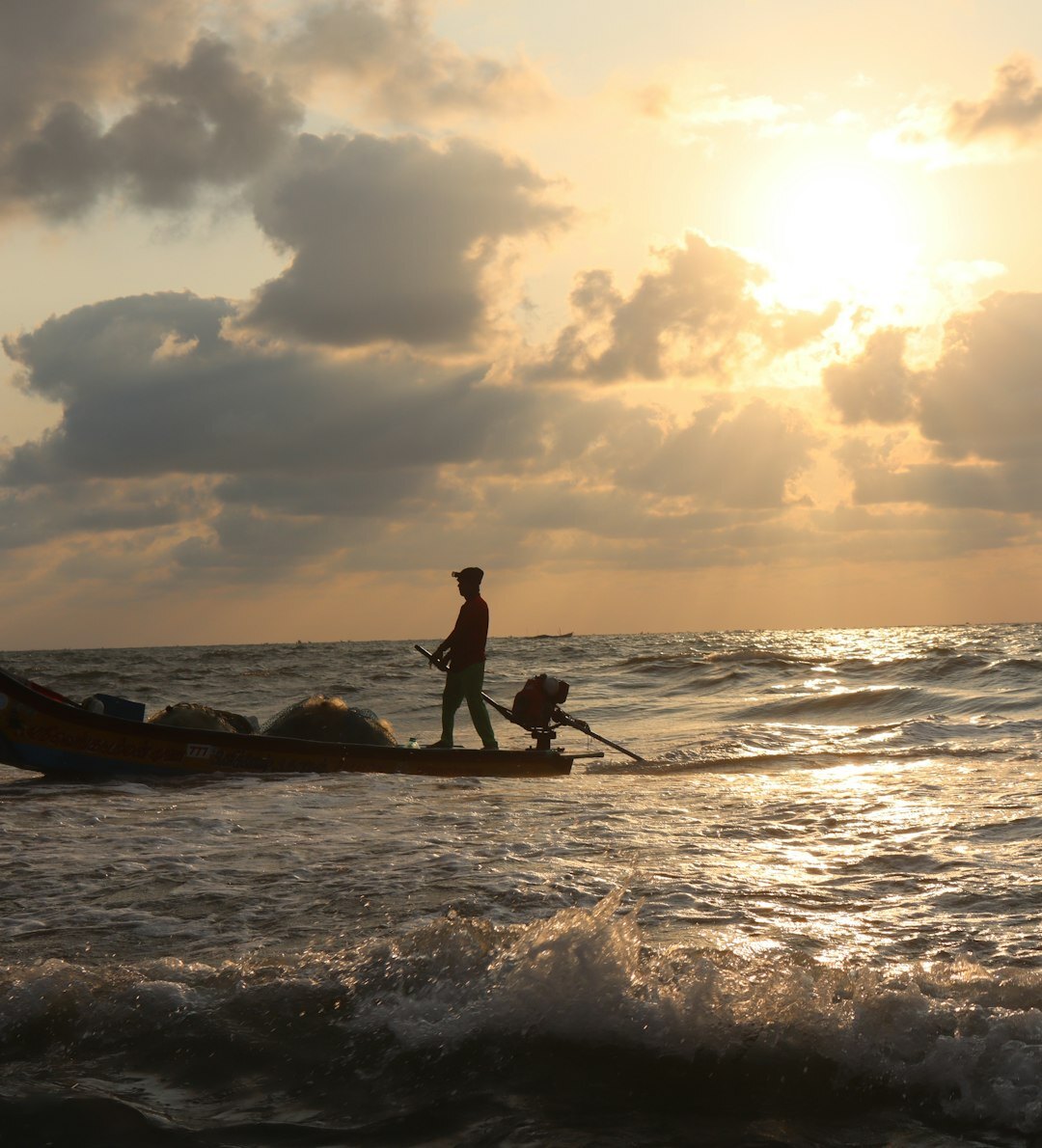 Elderly Chilean fisherman mending nets at a coastal cove